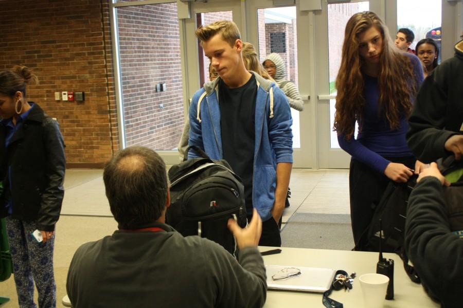 Junior Steven Miller and Sophomore Lilly Goldstein wait as their bags are searched by Mr. Zeller. Following the threat found on Friday, students have had their bags checked every morning upon arrival at school.