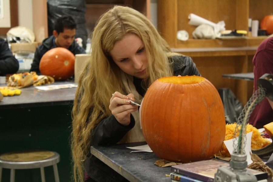 Junior+Bailey+Hummel+carves+her+pumpkin+in+Mr.+Holmes+ceramics+class.+This+is+the+first+time+Mr.+Holmes+has+had+students+carve+pumpkins+in+class.+
