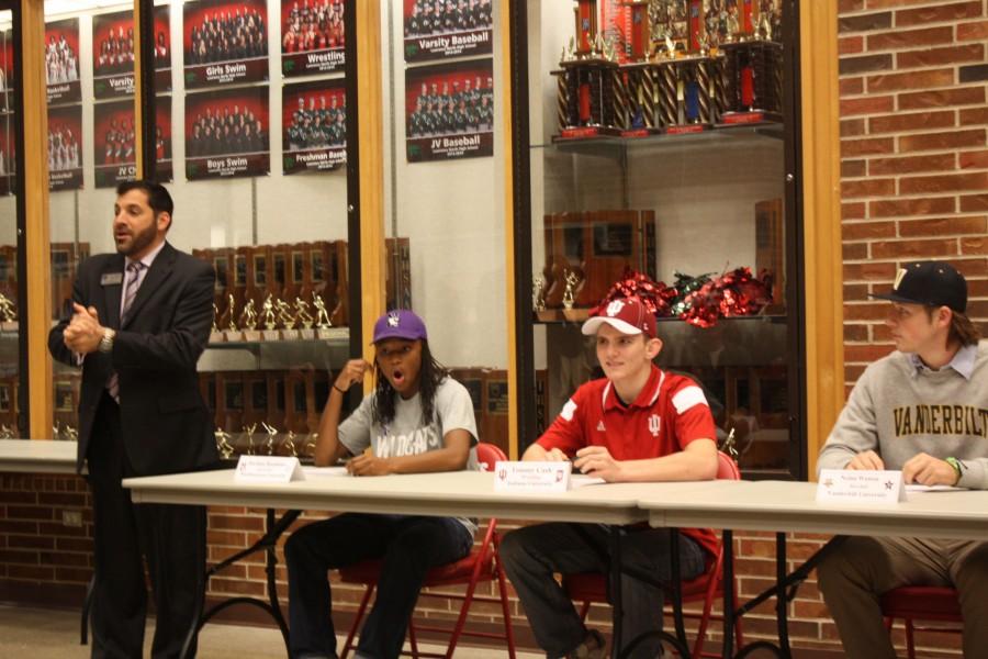Athletic Director Grant Nesbit talks to the audience as Northwestern commit Jordan Hankins, Indiana commit Tommy Cash, and Vanderbilt commit, Nolan Watson listen in. Lawrence North athletes gathered in front of friends, family and coaches to sign their letter of intent on Nov. 12.
